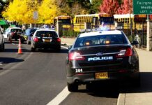 Surveillance Misuse Triggers Policy Changes Police cars with lights on near school buses on a city street