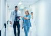 Four Patients Given Wrong Drug During Surgery Doctor and nurse walking in a hospital corridor reviewing a tablet