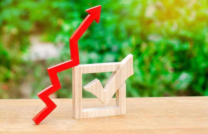 shutterstock_1193663686 Red upward arrow and wooden check mark on a table
