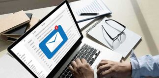 Hands typing on laptop with new email notification icon on screen