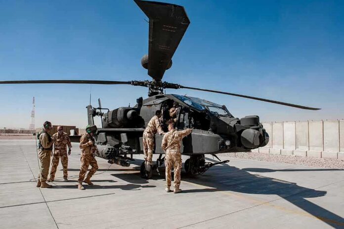 shutterstock_1229093725 Soldiers inspect a military attack helicopter on a tarmac