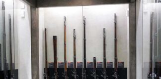 Display case with a row of antique muskets