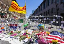 Boston College Honors 9/11 Hero With Red Bandanna Memorial with flowers and flags by street barricades