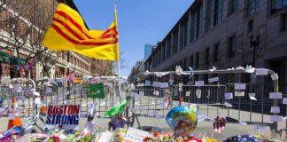 Memorial with flowers and flags by street barricades