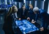 Business team reviewing digital map on illuminated table