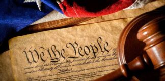 U.S. Constitution with gavel and flag