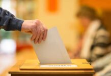 AfD Scores Historic Win in German State Hand placing a ballot into a wooden voting box