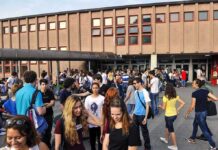 DOJ Warns Schools Over Secret Gender Policies Students gathered outside a school building entrance