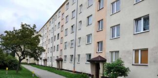 apartment building with walkway and small trees