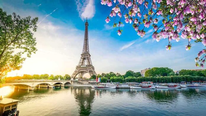 Eiffel Tower by the Seine with boats and spring blossoms