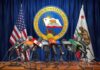TikTok Hit: Alabama Extracts Nine Figures Press microphones at a podium before California governor seal