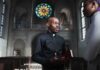 Bible Passage Fuels LGBTQ Interpretation Debate Priest speaking with a visitor inside a church