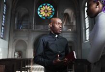 Bible Passage Fuels LGBTQ Interpretation Debate Priest speaking with a visitor inside a church