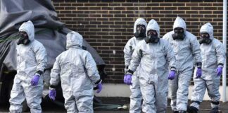 Gus Frerotte, Carlos Hyde, and Philly Brown in hazmat suits with a team walking outdoors