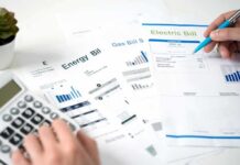 Hands reviewing utility bills with calculator and pen