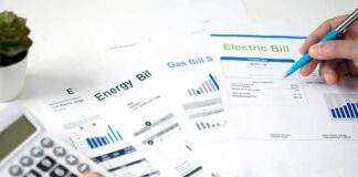 New York Expands Utility Bill Discounts Hands reviewing utility bills with calculator and pen