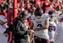 Coach Links Trump Exit to Comms Failure Mississippi State football coach and quarterback review play card on sideline