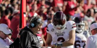 Coach Links Trump Exit to Comms Failure Mississippi State football coach and quarterback review play card on sideline