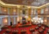 Congress Weaponizes Aid: Campuses On Notice Legislative chamber with red carpet and chandeliers