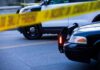 Gas Station Shooting Caught on Camera Police cars behind yellow caution tape at a street scene