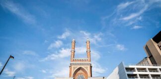 historic brick church with twin towers against blue sky