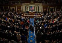 Trump-Era Tax Cuts Face Budget Questions Legislative chamber audience stands and applauds