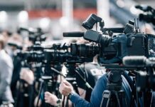Flag-Waving Protester Confronted at Convention Broadcast cameras on tripods at a press event