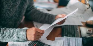 Burisma Board Income Linked to Active Crack Cocaine Addiction Person reviewing bills with calculator at cluttered desk