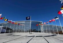 Poland Nears Permanent U.S. Military Base NATO headquarters with member flags in front under a clear blue sky