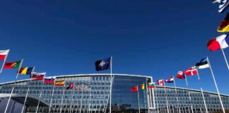 Poland Nears Permanent U.S. Military Base NATO headquarters with member flags in front under a clear blue sky