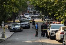 Enchilada Argument Ends in Fatal Shooting Police officers secure a residential street with patrol cars and yellow tape