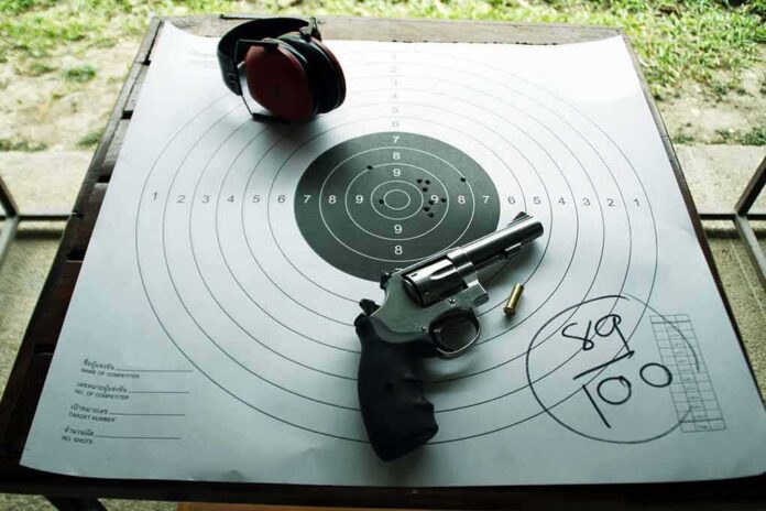 shutterstock_623754059-1 Revolver and ear protection on paper shooting target