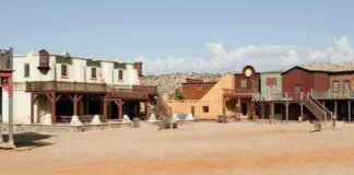 One Man Lives in a Ghost Town A deserted western town with historic buildings under a clear blue sky