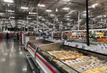 Supermarket dairy aisle with refrigerated cheese display cases