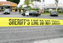Family Attacked in LA Mall Robbery yellow sheriff's line tape blocks a street near police cars