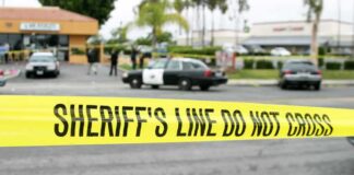 Family Attacked in LA Mall Robbery yellow sheriff's line tape blocks a street near police cars