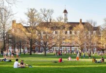 Campus Free Speech Battles Intensify Students relaxing on a campus quad in front of a brick academic building