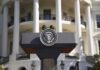 Trump Weighs Firing Ambassador Over $100K Claim Presidential podium with seal in front of white-columned building