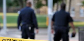 Japan Protests After Marine Arrest in Okinawa Killing Police officers walking past caution tape at a crime scene