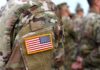 U.S. Troops Receive a Long-Awaited Pay Boost U.S. flag patch on a camouflage military uniform