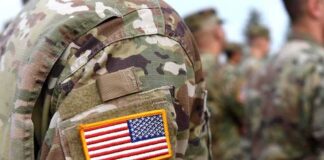 U.S. Troops Receive a Long-Awaited Pay Boost U.S. flag patch on a camouflage military uniform