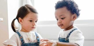 Toddlers playing with colorful stacking cups at a table