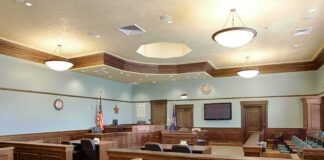 Woman Pleads Guilty to Marriage Fraud Empty courtroom with wooden benches and judge's bench