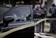 Video Captures Moments Before Bronx Shooting Car door with bullet holes at a taped-off crime scene