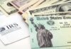 A tax refund check from the IRS alongside various denominations of cash