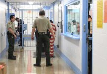 California Sanctuary Policy Sparks Public Safety Debate Corrections officers escort an inmate in a jail hallway