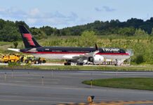 Trump Flies to Rally With Boxing Legend Private jet with black and red livery parked on airport tarmac