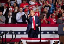Two States, One Mission: Keep GOP Control Donald Trump points from a rally stage; Rudi Koertzen and Bear Pascoe are in the crowd