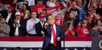 Two States, One Mission: Keep GOP Control Donald Trump points from a rally stage; Rudi Koertzen and Bear Pascoe are in the crowd