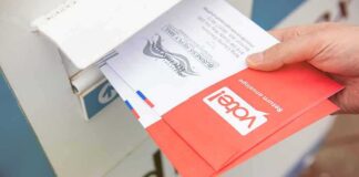 California Ballots Face Federal Challenge Hand dropping mail-in ballots into a drop box